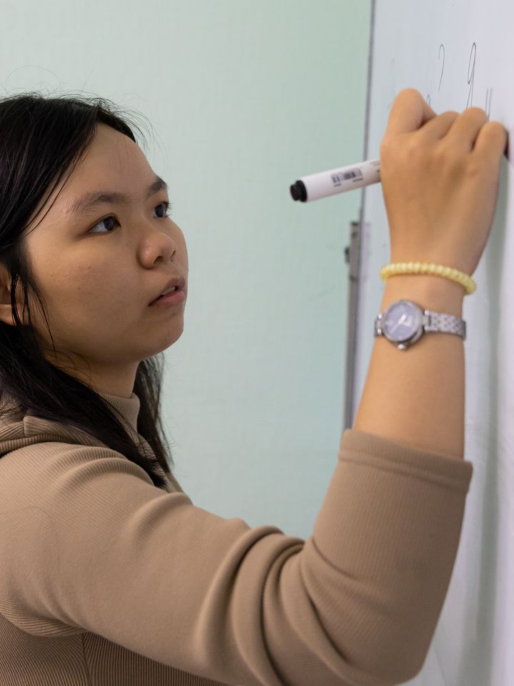 A Foundation programme student writing in Russian on the board