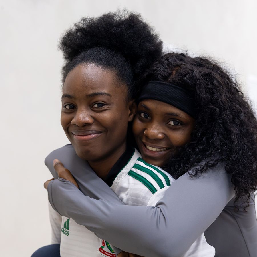 Two friends hugging and smiling