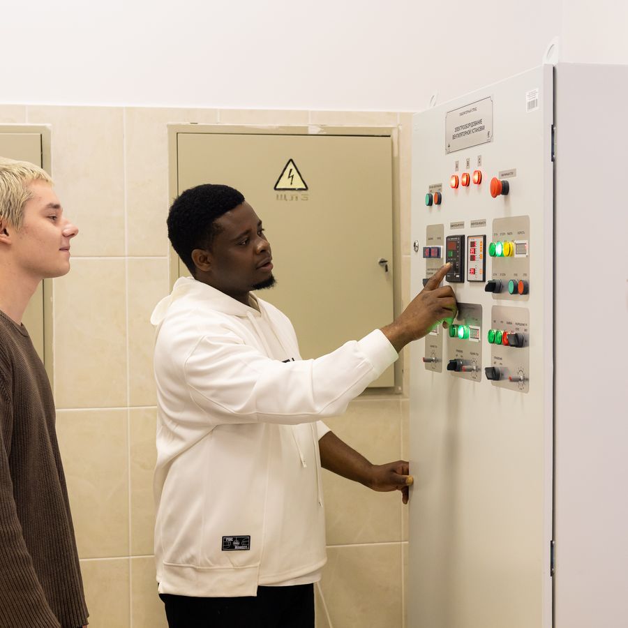 A student operating a control panel in an engineering lab