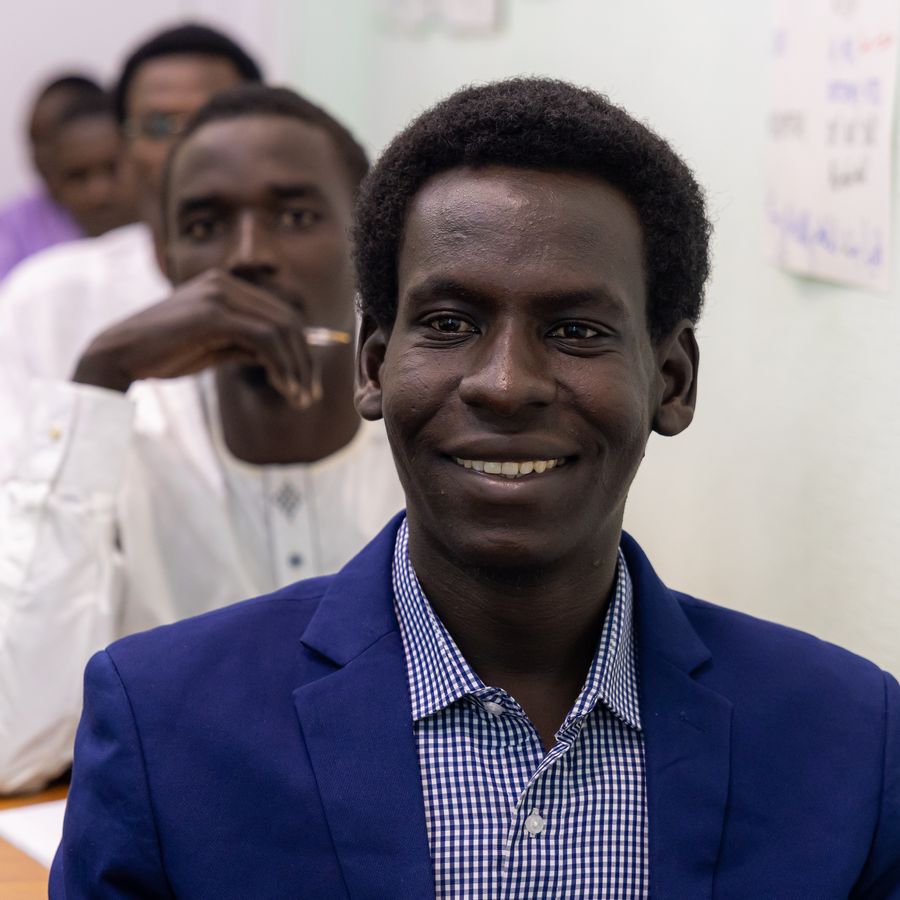 A smiling student in a blazer in class