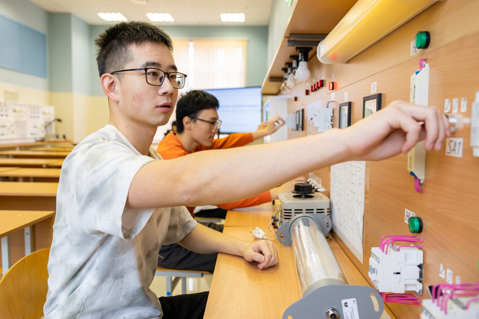 International students assembling circuits at an electrical engineering lab bench
